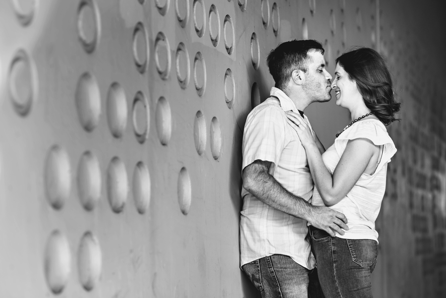 A woman pushes her fiance up against a wall for a kiss in this fishtown engagement session.